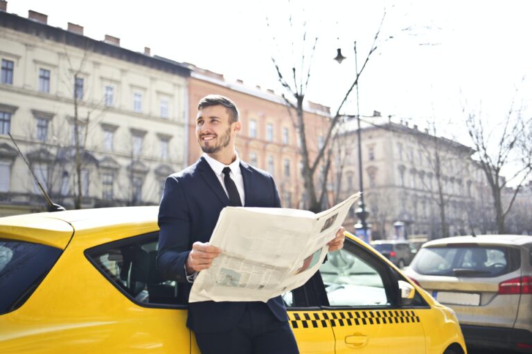 Werte vermitteln: Ein Mann lehnt am Auto und liest eine Zeitung