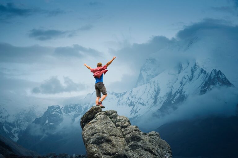 Ein Mann steht auf einem Klippenvorsprung. Das Titelbild für den Beitrag 'Wie du die Autonomie und die Eigenverantwortung in deinem Team förderst'