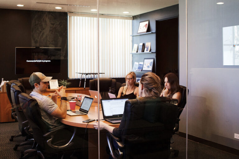 Ein Meeting hinter einer Glaswand. Da fragt man sich: Meetings sind Zeitverschwendung, stimmt das?