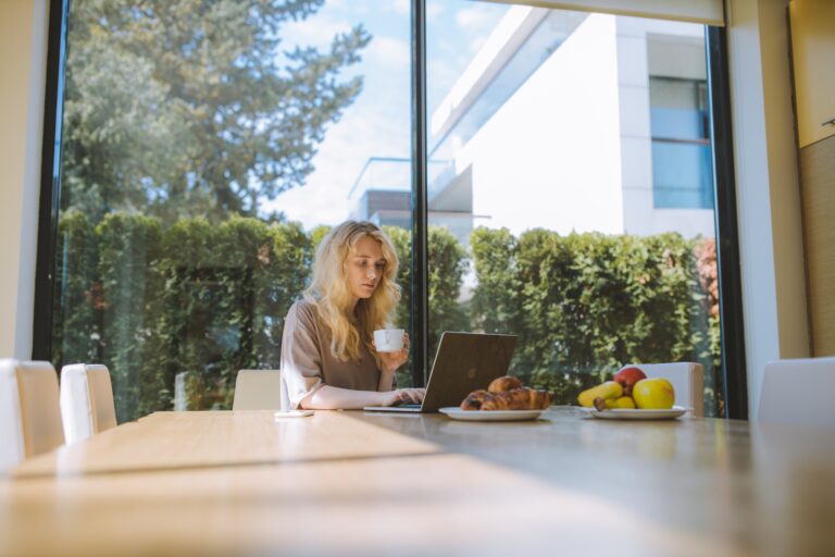 Eine Frau arbeitet an ihrem Küchentisch. Das ist Remote Führen im Home-Office.