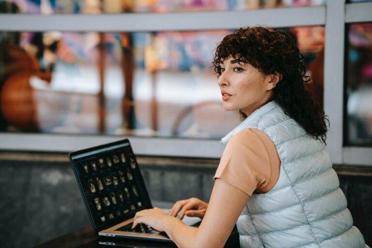 Eine Frau sitzt am Laptop und denkt nach. Als Titelbild für einen Artikel über Selbsterkenntnis.