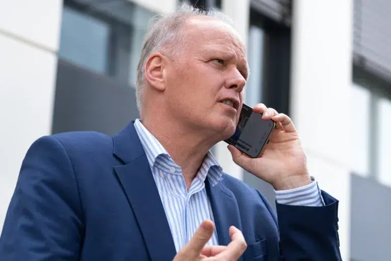 Gestresster Kai Boyd am Handy, erzählt im Artikel ‚stabiles Team aufbauen‘ von seinen Erfahrungen, wie man aus dem Dauerstress herauskommt