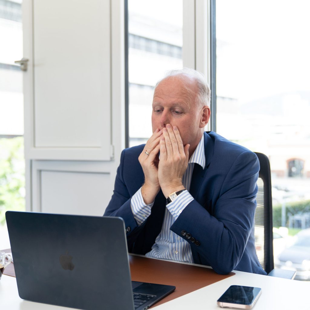 Kai Boyd verzweifelt vor dem Laptop – Ausgangspunkt seines Webinars über den Umgang mit schwierigen Mitarbeitenden